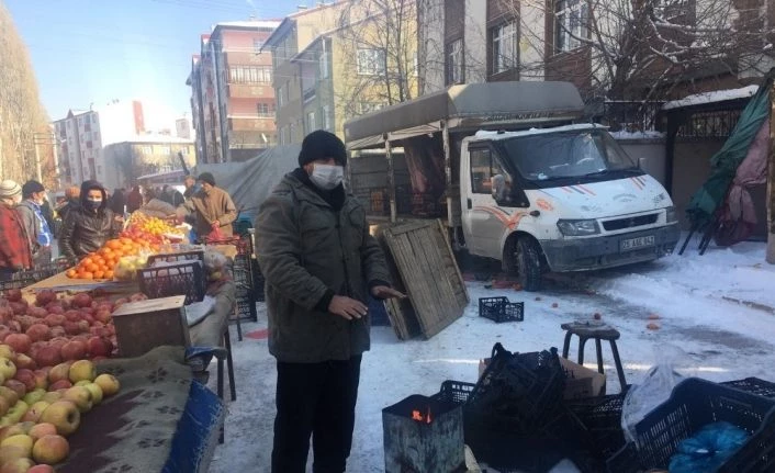 Pazarcılar soğuk havada açık alana kurdukları soba ile ısınıyor